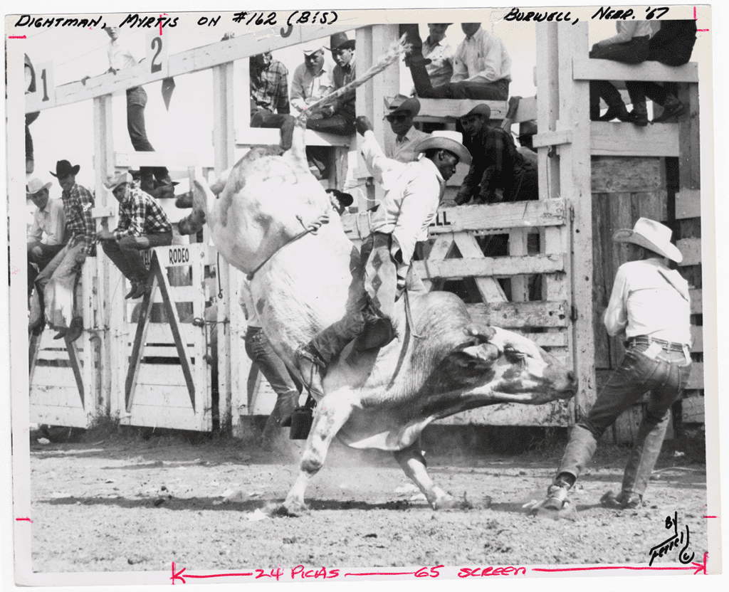 Myrtis Dightman is riding a bull at Burwell, Nebraska. 